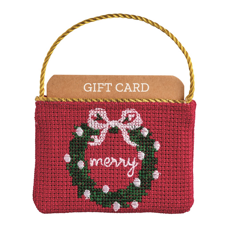 Red needlepoint gift card pouch with a green wreath, white bow, and 'merry' text.