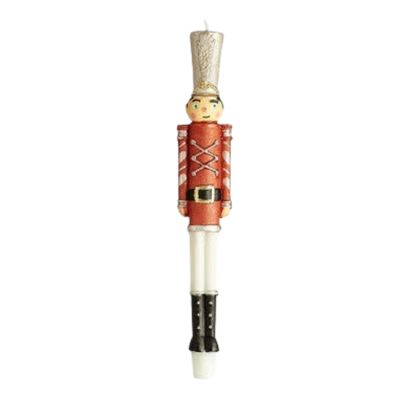 Nutcracker soldier taper candle with a red uniform, silver hat, and black boots.