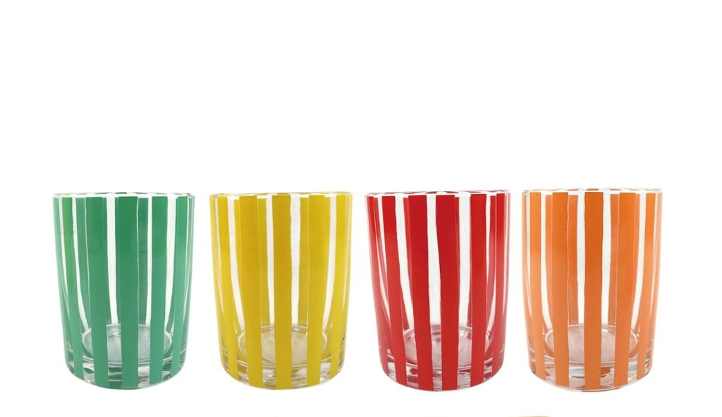 Four handblown juice glasses with green, yellow, red, and orange vertical stripes.