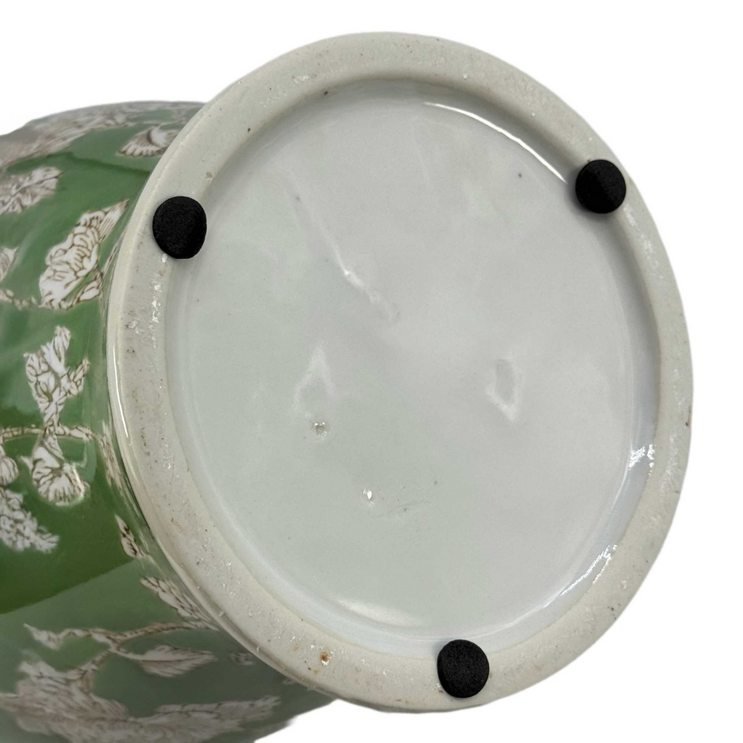 Bottom view of a green and white chinoiserie ginger jar showing the base with three felt pads.