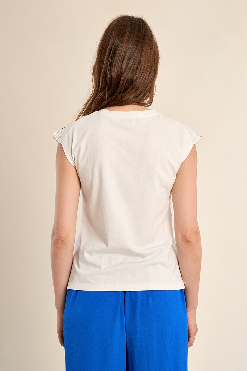 Back view of a woman wearing a white cotton Madison knitted tee with embroidered cap sleeves.