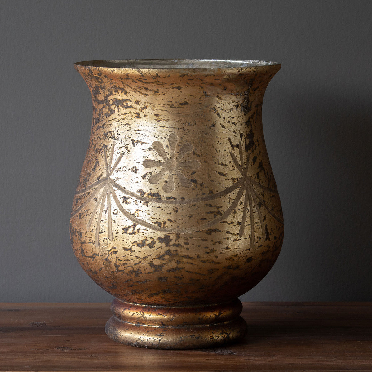 Antiqued bronze hurricane lamp with etched glass shade featuring a decorative pattern.