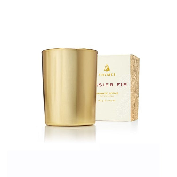 Frasier Fir Votive Candle in a gold metallic glass holder next to its white and gold box.