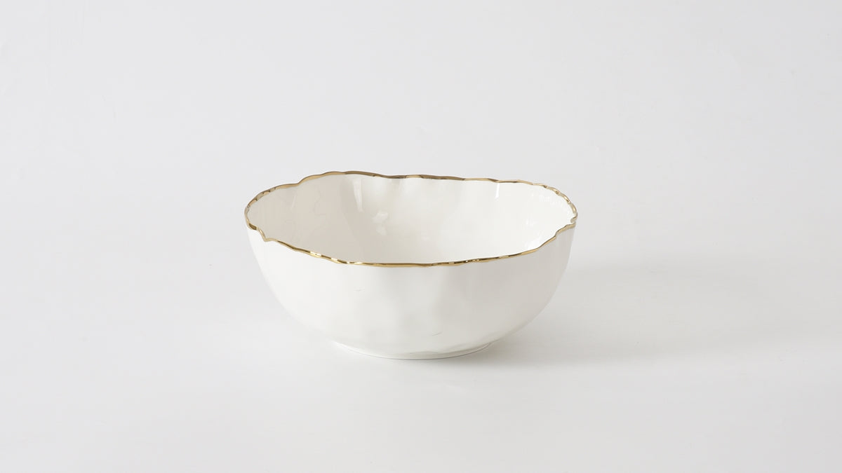 Medium white porcelain bowl with an organic wavy shape and a gold-colored rim.