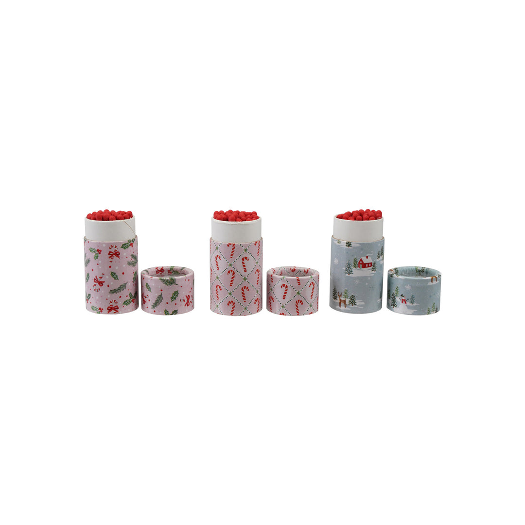 Three sets of holiday-patterned safety match tubes with red-tipped matches and matching caps.