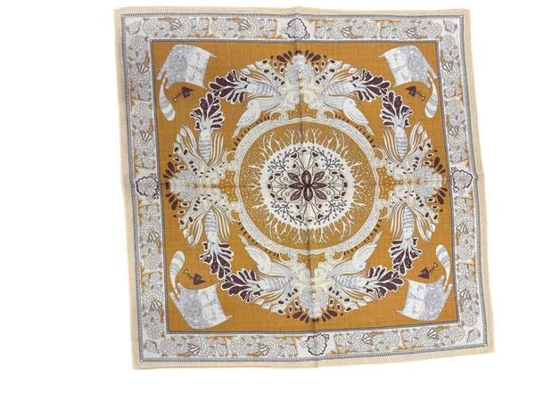 Square reversible wool and silk scarf in mustard yellow with intricate white and grey folk art.