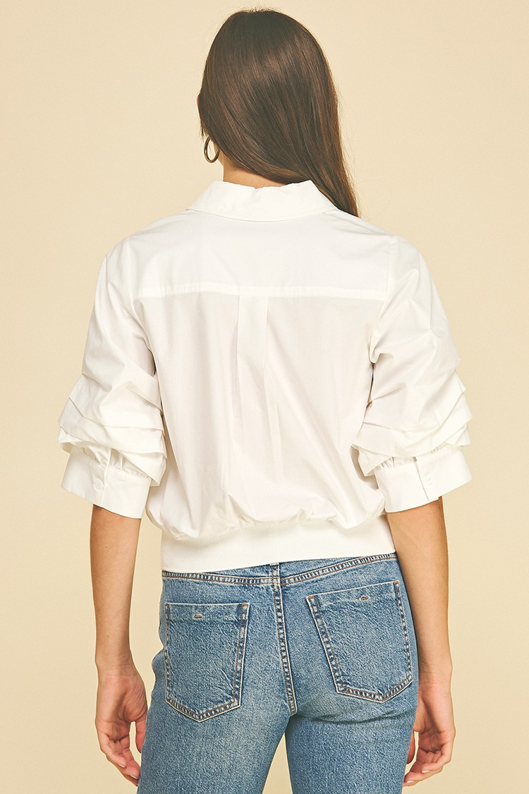 Back view of a white Jaycee cropped shirt with pleated sleeves and a banded hem.