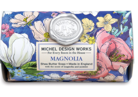 Michel Design Works Magnolia shea butter soap bar with a floral pattern on a blue background.