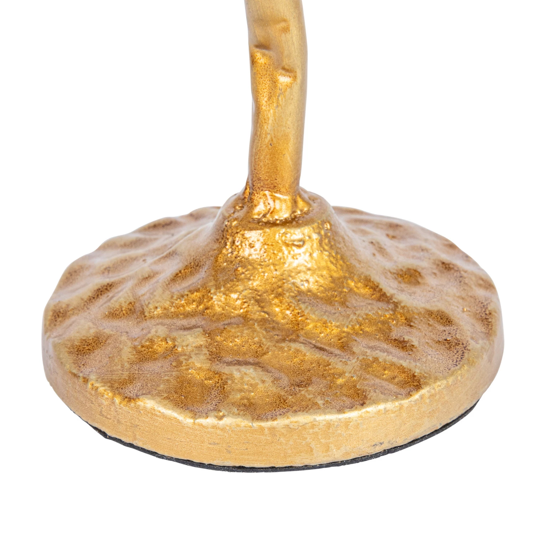 Close-up of the hand-forged gold finish base and stem of a metal candle holder.