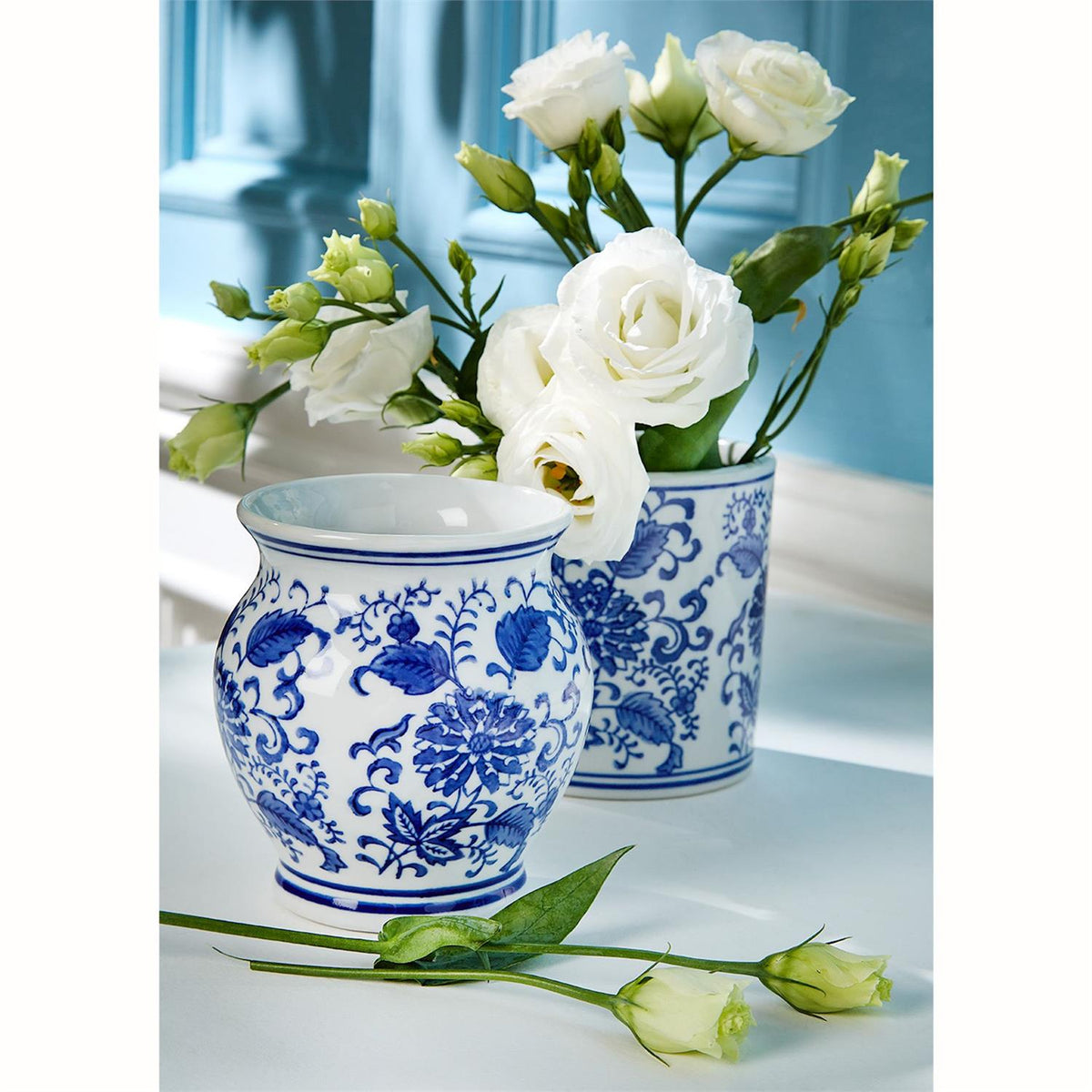 Small ceramic chinoiserie vase with hand-painted blue floral patterns on a white background.