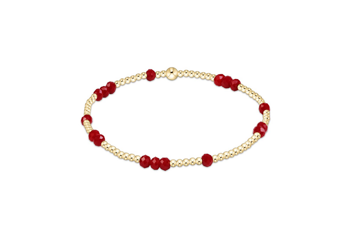 Gameday Flirty Hope Unwritten Bracelet with gold beads and faceted red crystal accents.