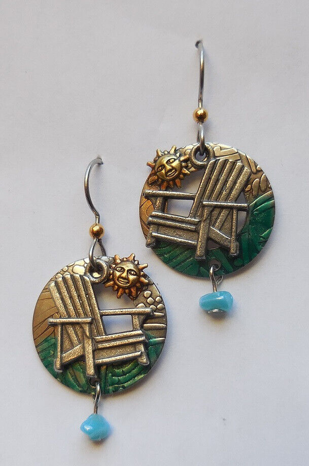 Silver dangle earrings featuring a beach chair, a smiling sun, and a blue bead drop.