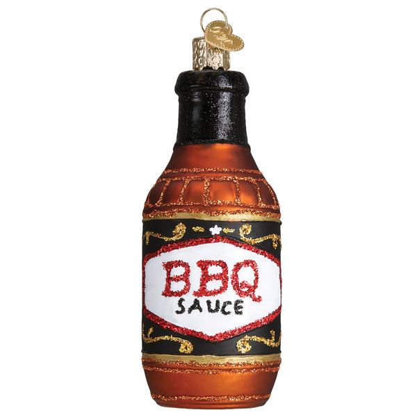 Glass Christmas ornament shaped like a brown BBQ sauce bottle with a white and red glitter label.