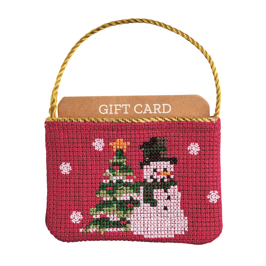 Red needlepoint gift card pouch with a snowman and Christmas tree design and a gold cord hanger.