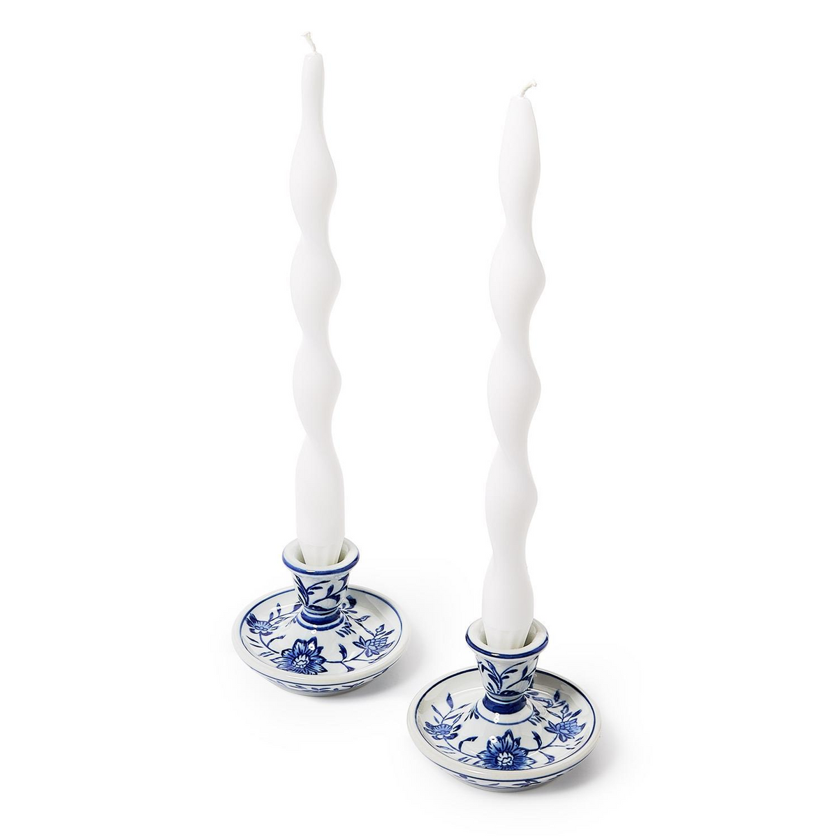 Two hand-painted blue and white chinoiserie ceramic taper candleholders with white wavy candles.