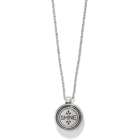 Silver round pendant necklace with 'SHINE' engraved on the back and a delicate chain.