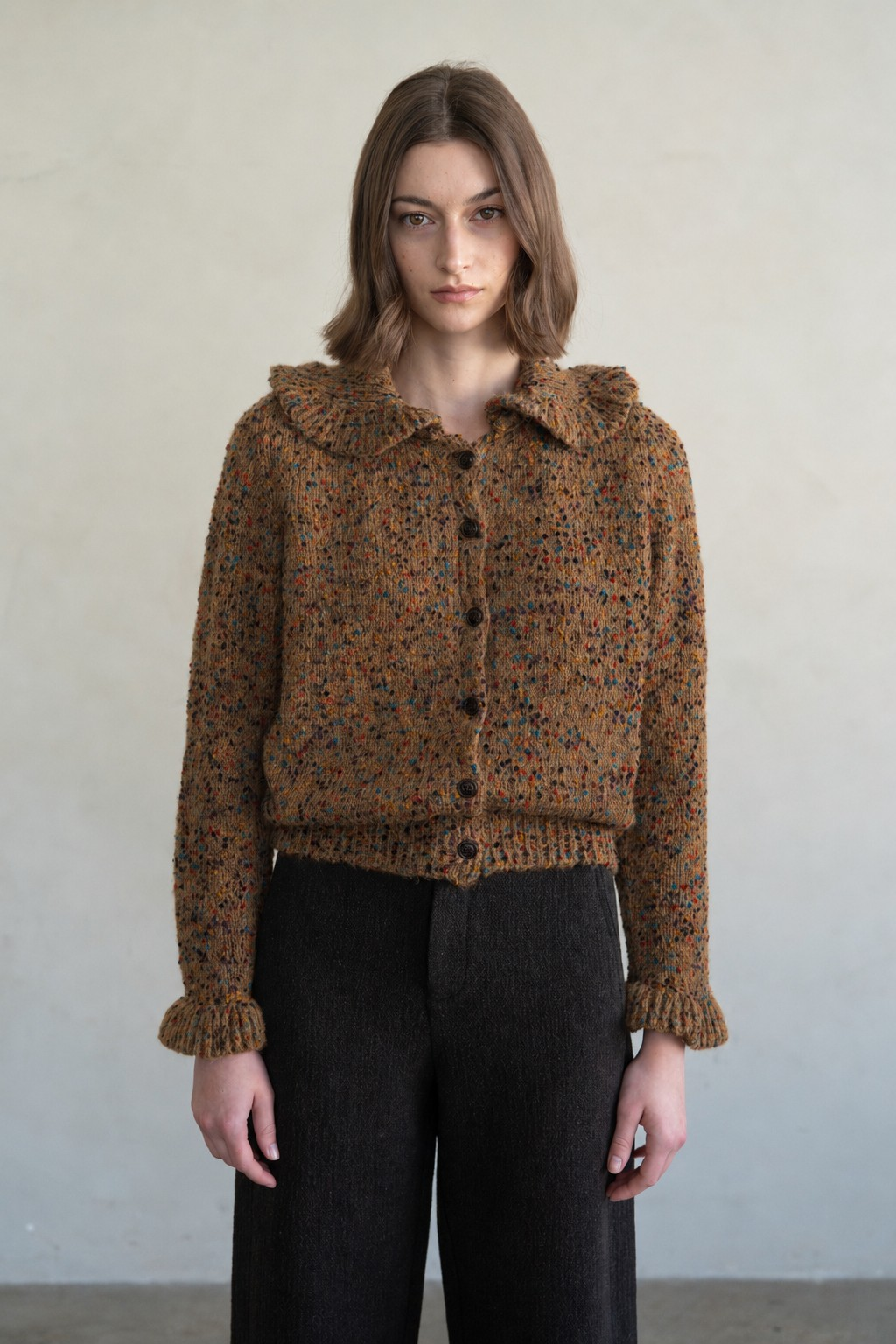 Woman wearing the Amanda Flecked Ruffle Collar Cardigan in brown with multi-colored flecks.