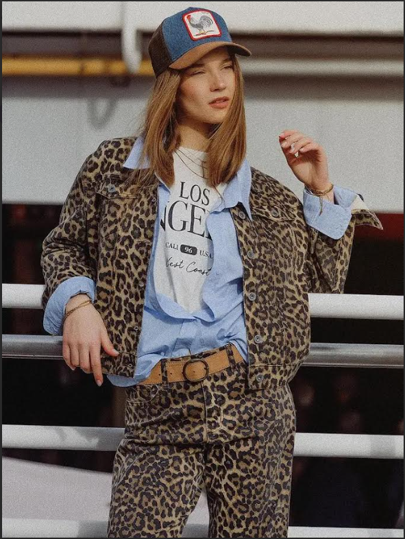 Woman wearing a leopard print denim jacket with a blue contrast collar and matching pants.