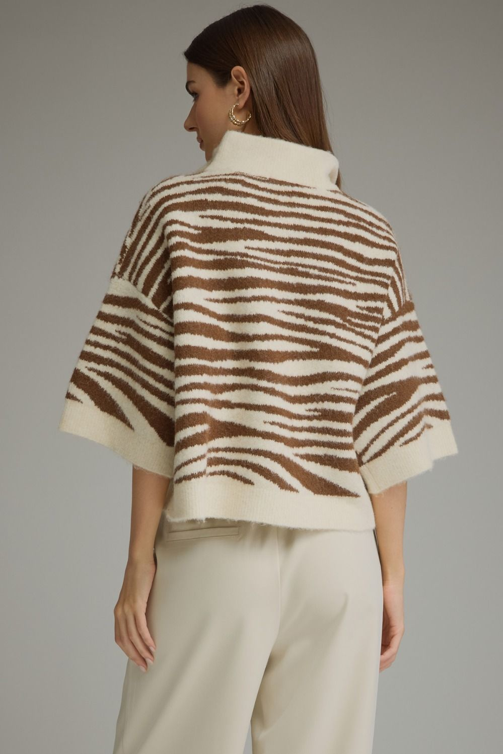 Back view of a woman wearing a Chanice abstract animal print 3/4 sleeve knit top in cream and brown.