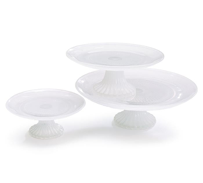 Set of three white milk glass cake plates in varying sizes with fluted pedestal bases.