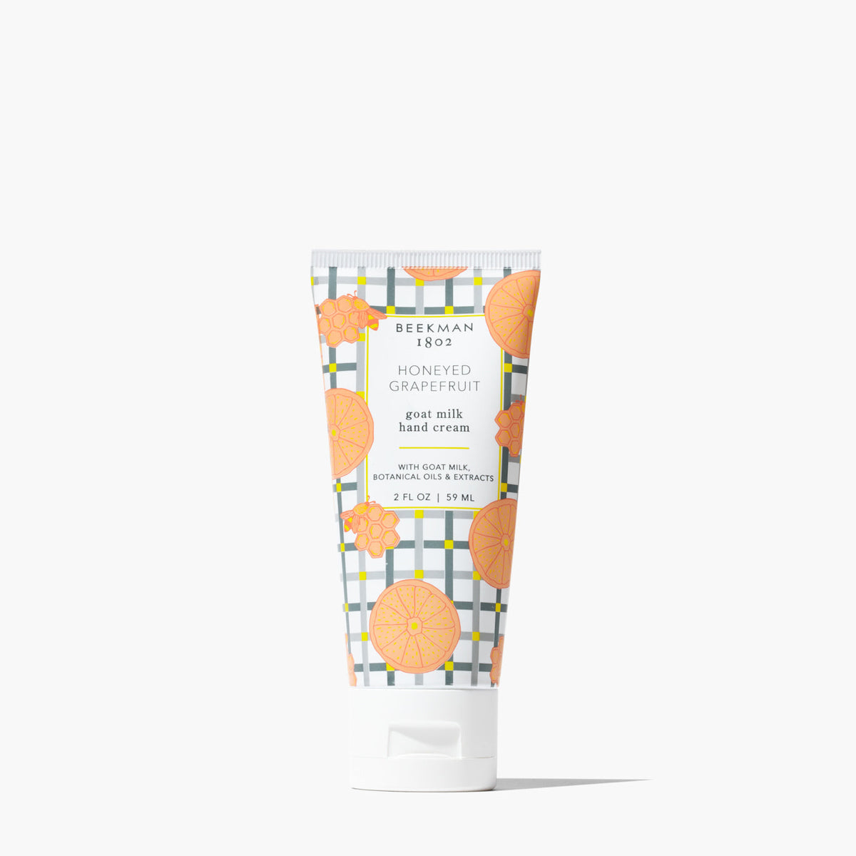 Beekman 1802 Honeyed Grapefruit goat milk hand cream in a 2 oz tube with citrus and plaid patterns.