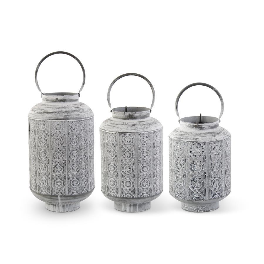 Set of three whitewashed medallion punched metal lanterns with handles in varying sizes.