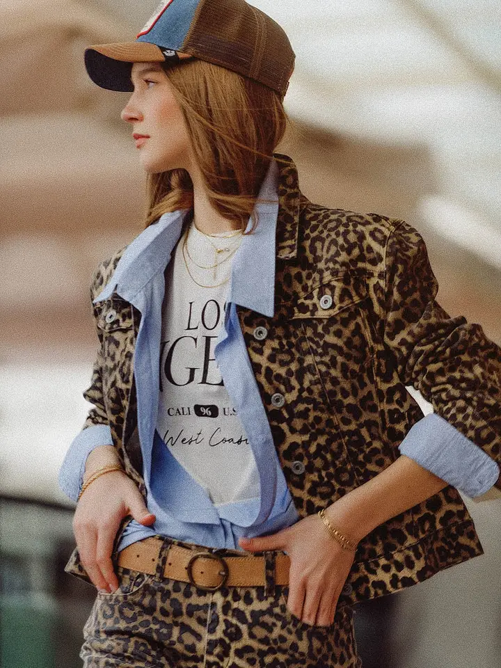 Woman wearing a Tasha Leopard Print Denim Jacket with a blue contrast collar and cuffs.