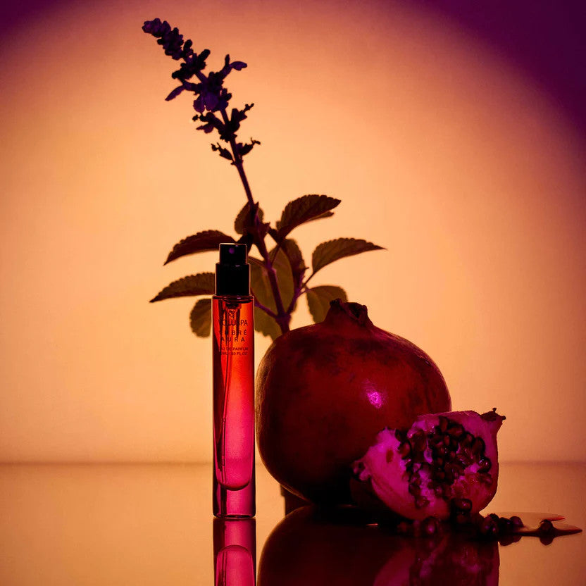Bottle of Ombre Aura Eau De Parfum with a gradient amber liquid inside and a dark cap.