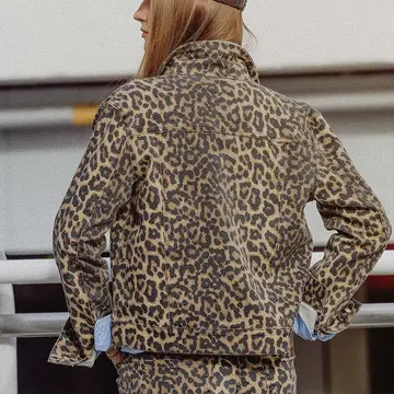 Back view of a woman wearing the Tasha leopard print denim jacket with blue cuff details.