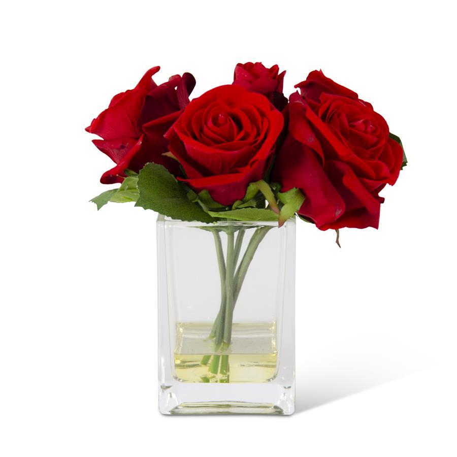 Square glass vase holding eight artificial red roses.