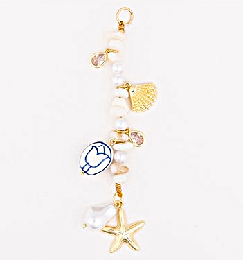 Tropical bag charm with gold plating featuring a leaf motif.