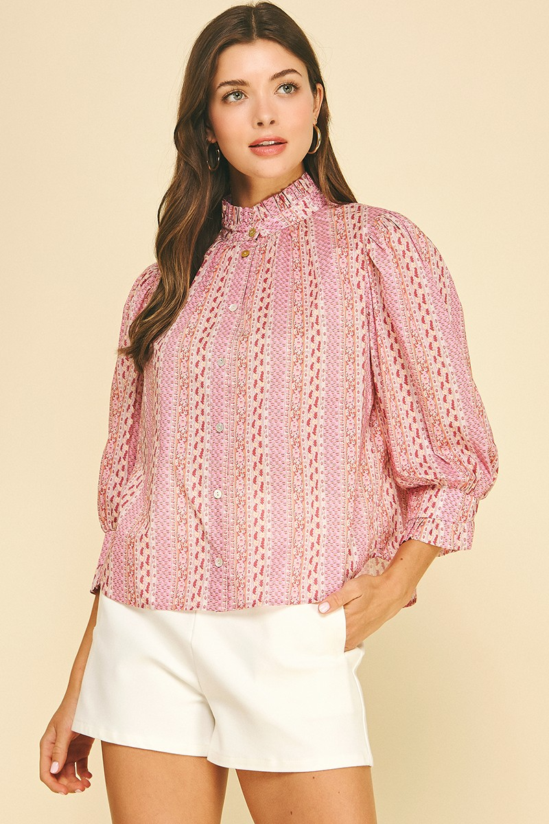 Woman wearing a pink Mabel floral botanical print button-down blouse with white shorts.