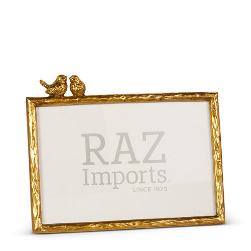 Gold metal bird picture frame with glass front holding a photo