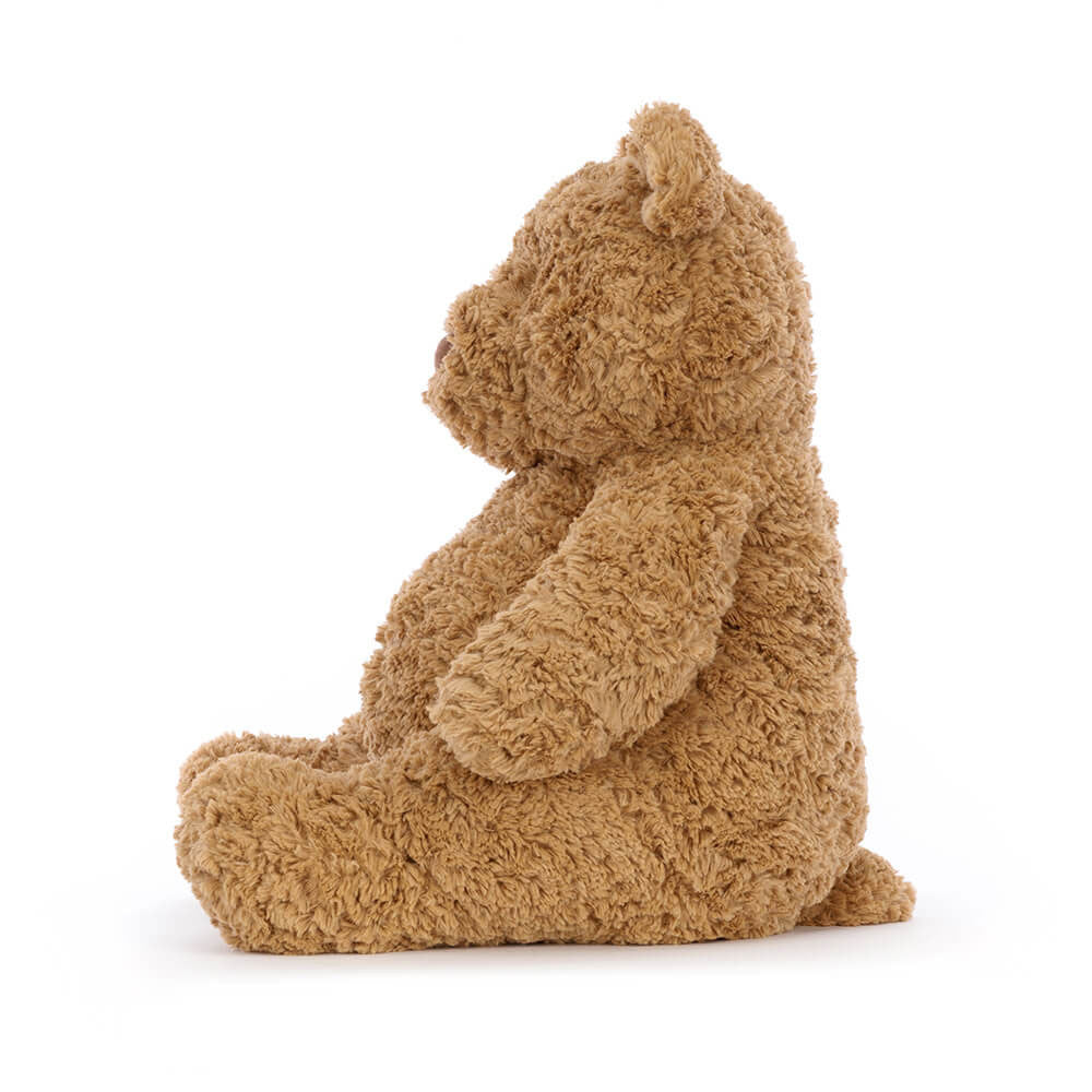 Side view of Bartholomew Bear, a medium-sized tawny brown plush teddy bear in a sitting position.
