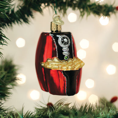Red glass air fryer Christmas ornament with gold french fries hanging on a pine tree branch.