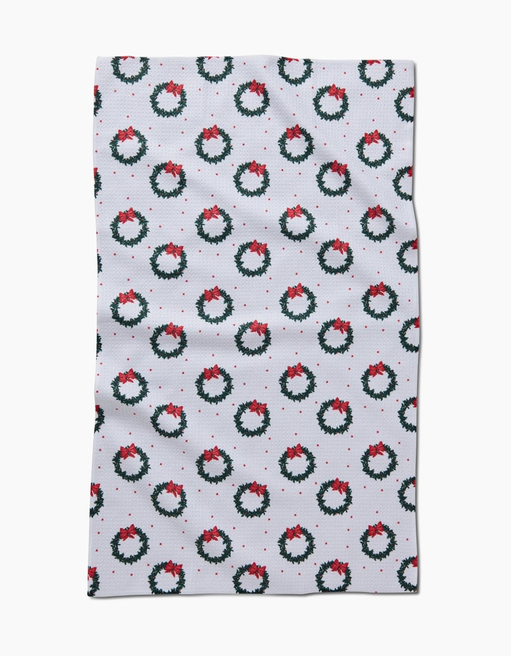 Holiday tea towel with waffle weave construction in red featuring a festive snowman pattern.
