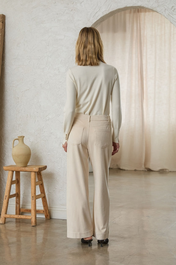 Rear view of a woman wearing cream-colored Lucy Faux Suede Wide Leg Pants with back pockets.