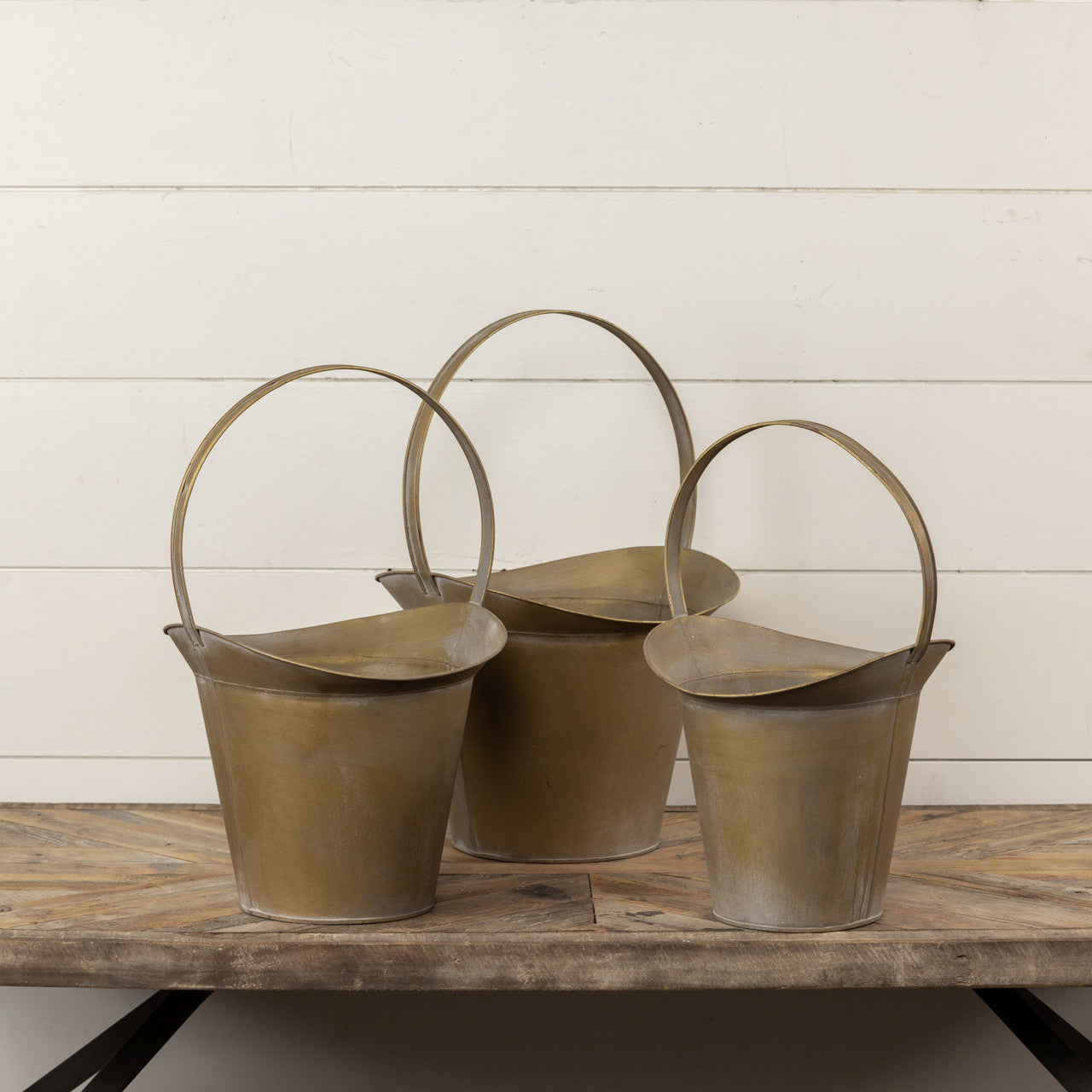 Gold metal slope bucket with a curved handle.