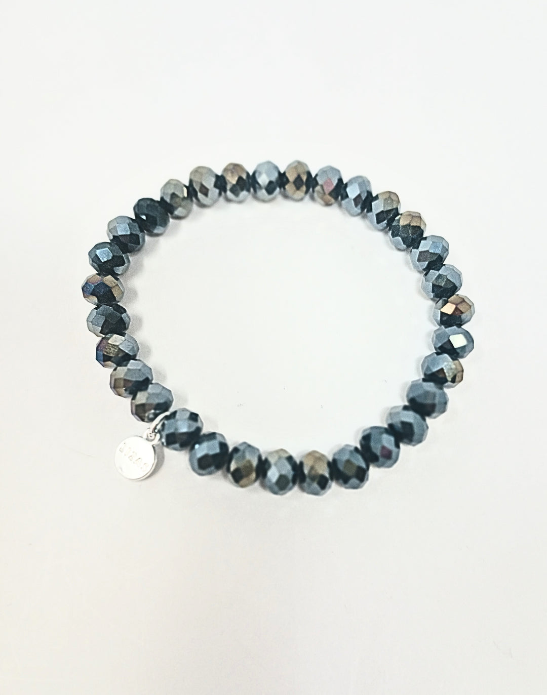 Stretchy bracelet made of dark grey faceted glass beads with a small silver logo charm.