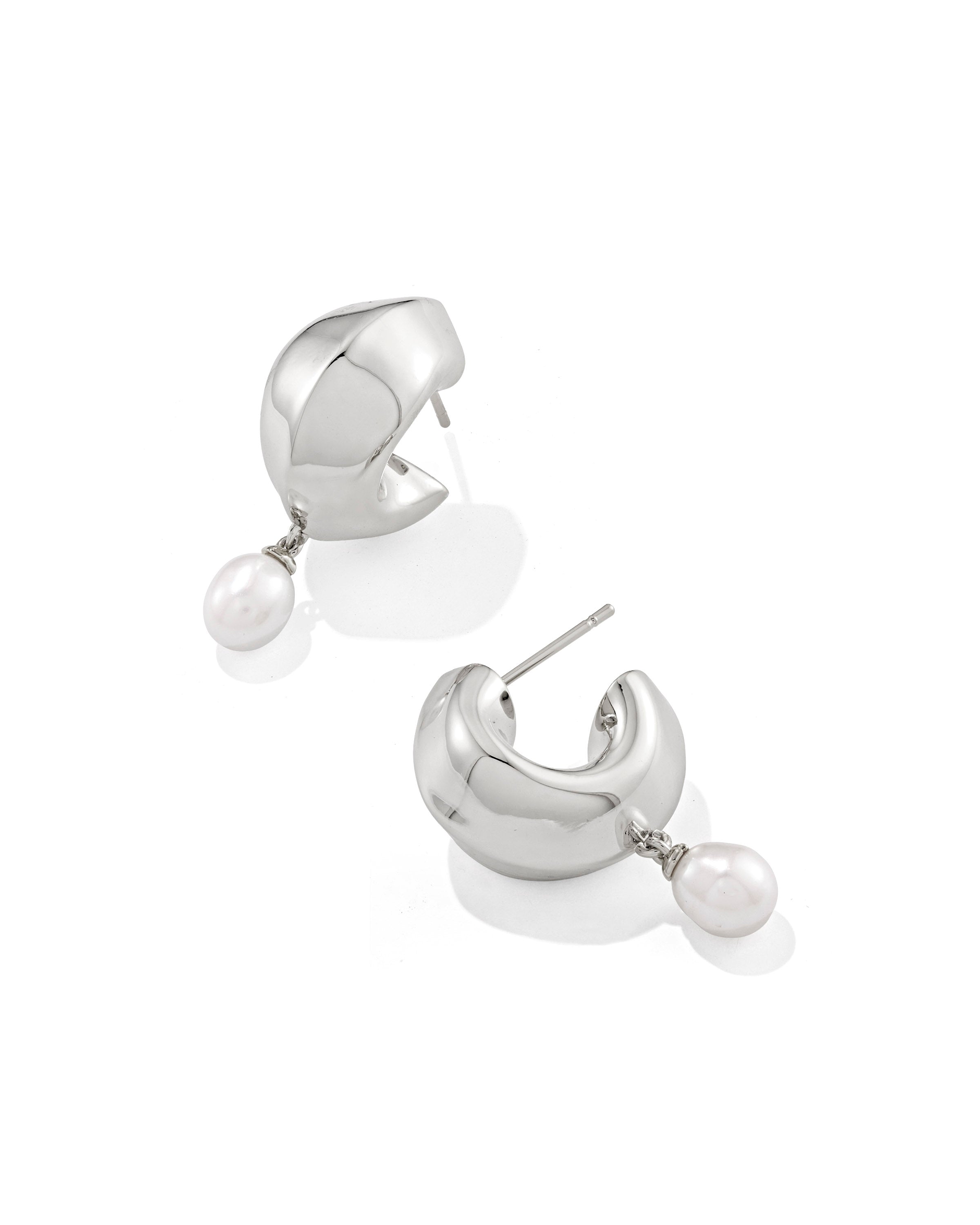 Silver Oakland Pearl Huggie Earrings featuring chunky silver hoops with dangling white pearls.