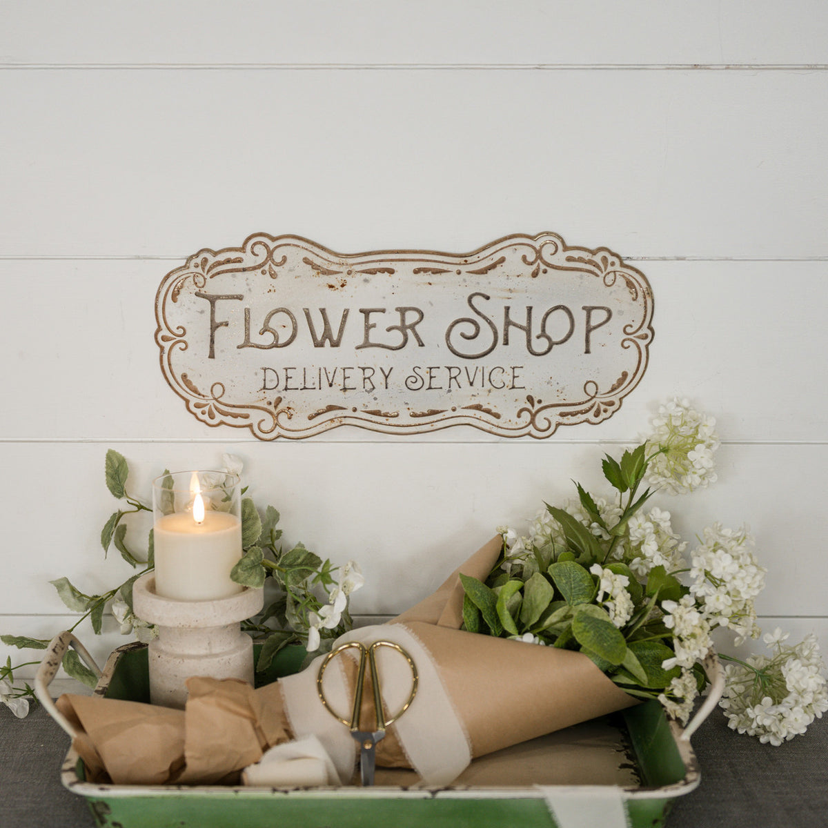 Metal flower shop sign with a vintage-style floral illustration on a white background.
