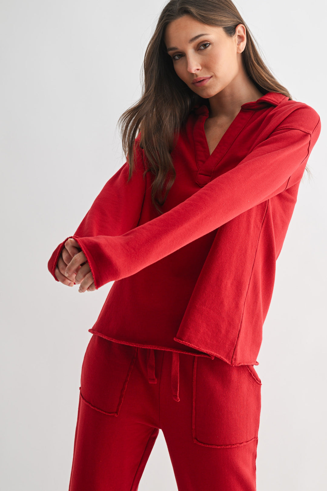 Woman wearing a red Virginia Malibu Vintage Henley Tee and matching red sweatpants.
