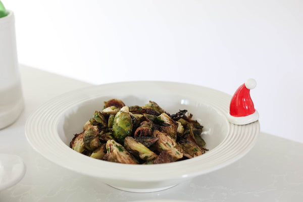 White Pinstripes Biggie Bowl filled with roasted brussels sprouts and a Santa hat decorative charm.