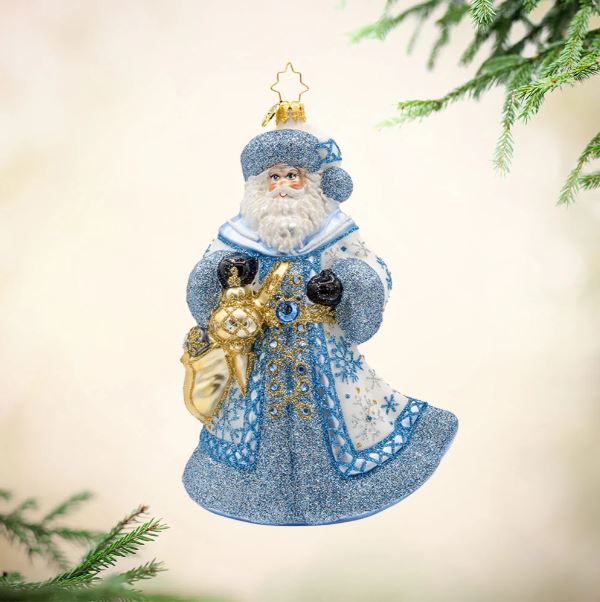 Ivory Frost Santa glass ornament in a blue and white glittered coat holding a gold sack.