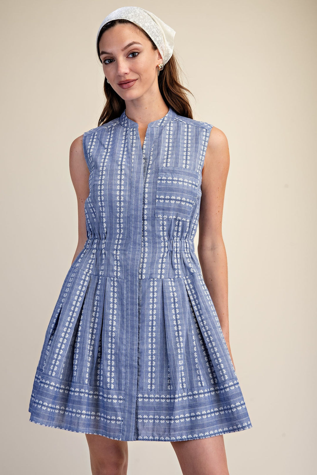 Sleeveless blue and white embroidered fit and flare mini dress with a cinched waist and V-neckline.
