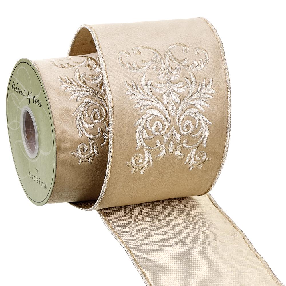 4-inch wide gold velvet ribbon with embroidered damask pattern on a spool.