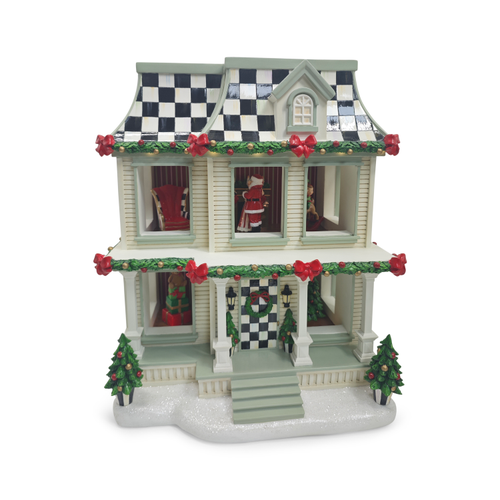 Two-story Christmas farmhouse display with checkered roof, festive garlands, and Santa inside.