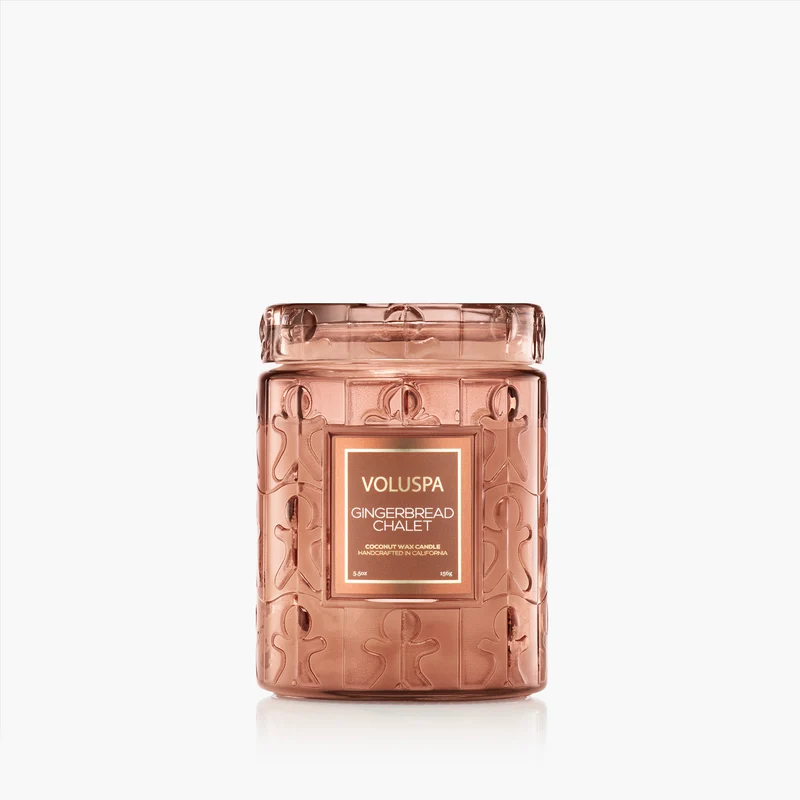 Voluspa Gingerbread Chalet 5.5oz candle in a copper-toned glass jar with gingerbread man patterns.