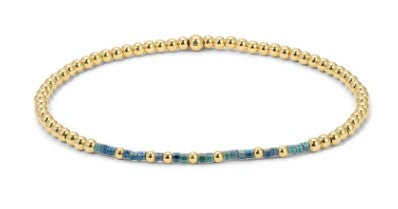 Dream Big Bracelet with 14K gold-filled beads and blue accents on an elastic band.