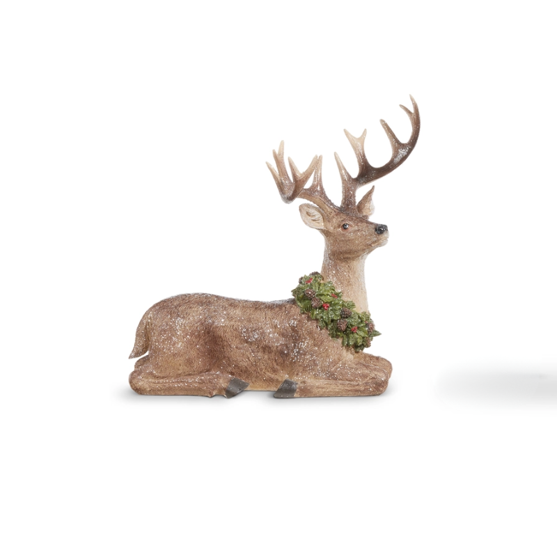 Resin deer figurine lying down with antlers and a festive green wreath around its neck.